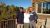 Three people stand on a lodge deck at Glacier National Park during fall foliage on a sunny afternoon.