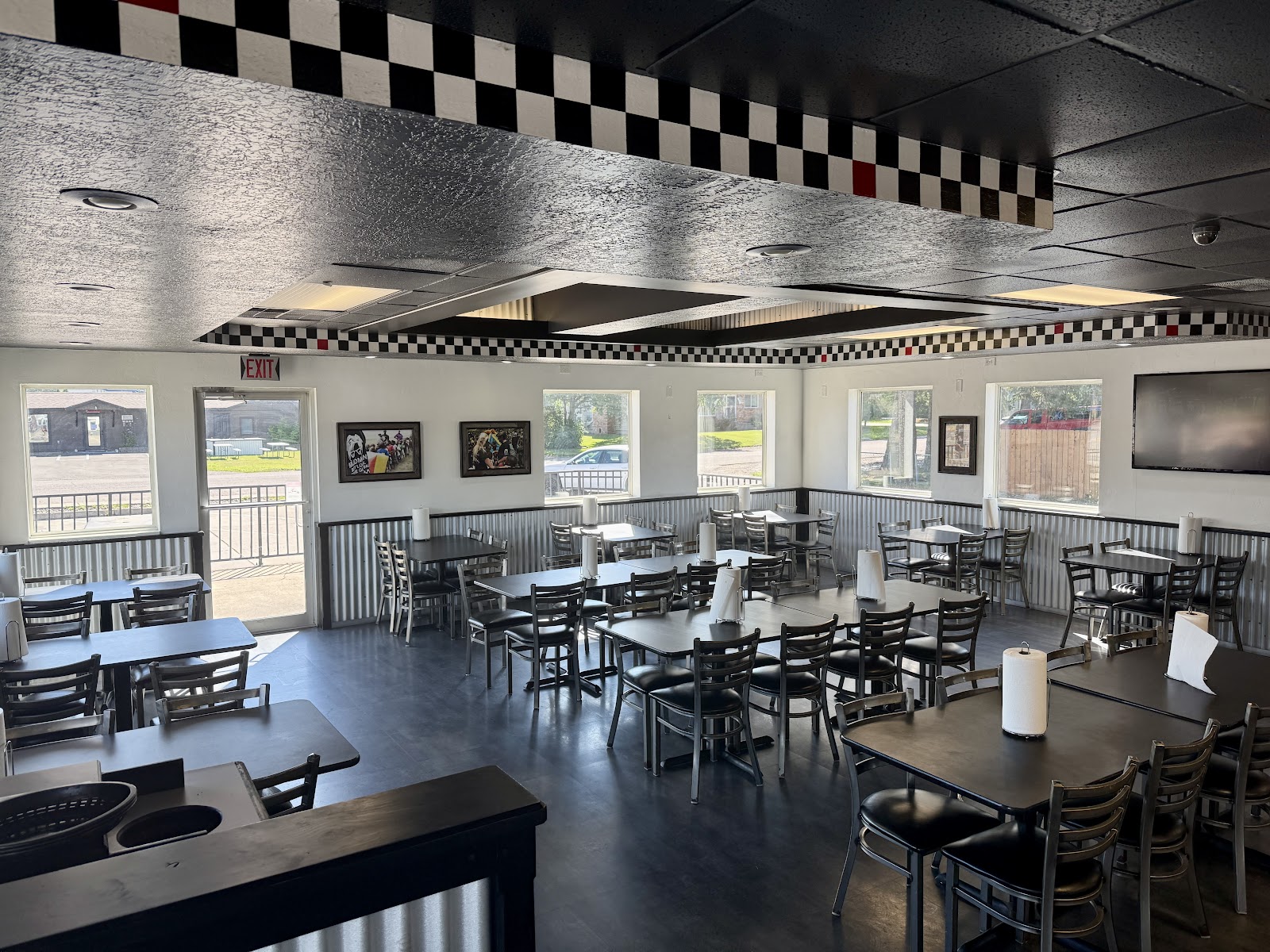 Spacious Glacier National Park restaurant dining room with corrugated metal walls and a checkerboard ceiling.