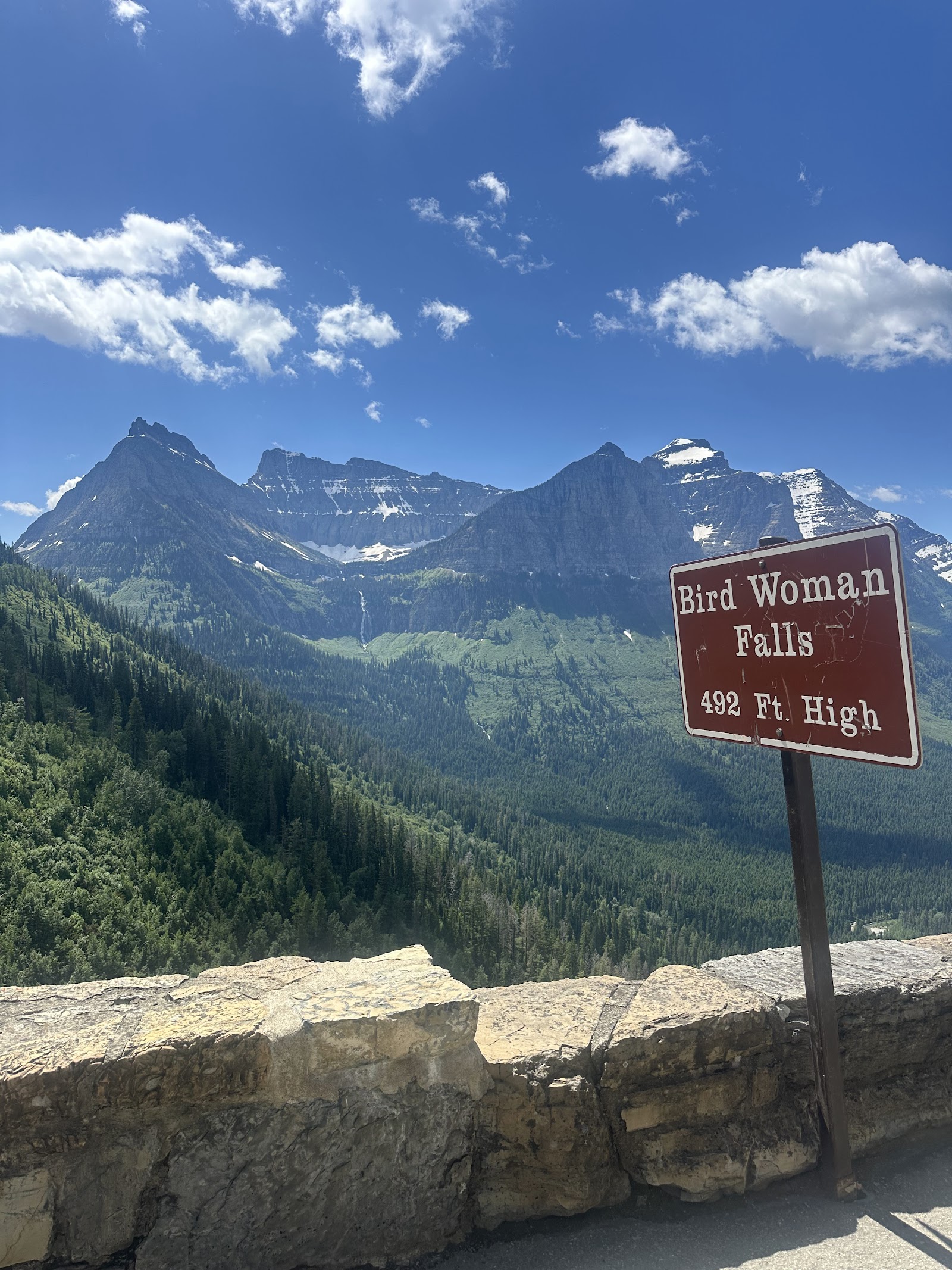 Bird Woman Falls Overlook in Glacier National Park showcases cascading falls beneath rugged snowcapped peaks.