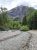 Avalanche Creek Picnic Area in Glacier National Park, with a rocky stream, green trees, and towering mountain backdrop.