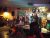 Live band performs on a compact indoor stage at a Glacier National Park bar venue, with drums, guitars, and patrons watching.