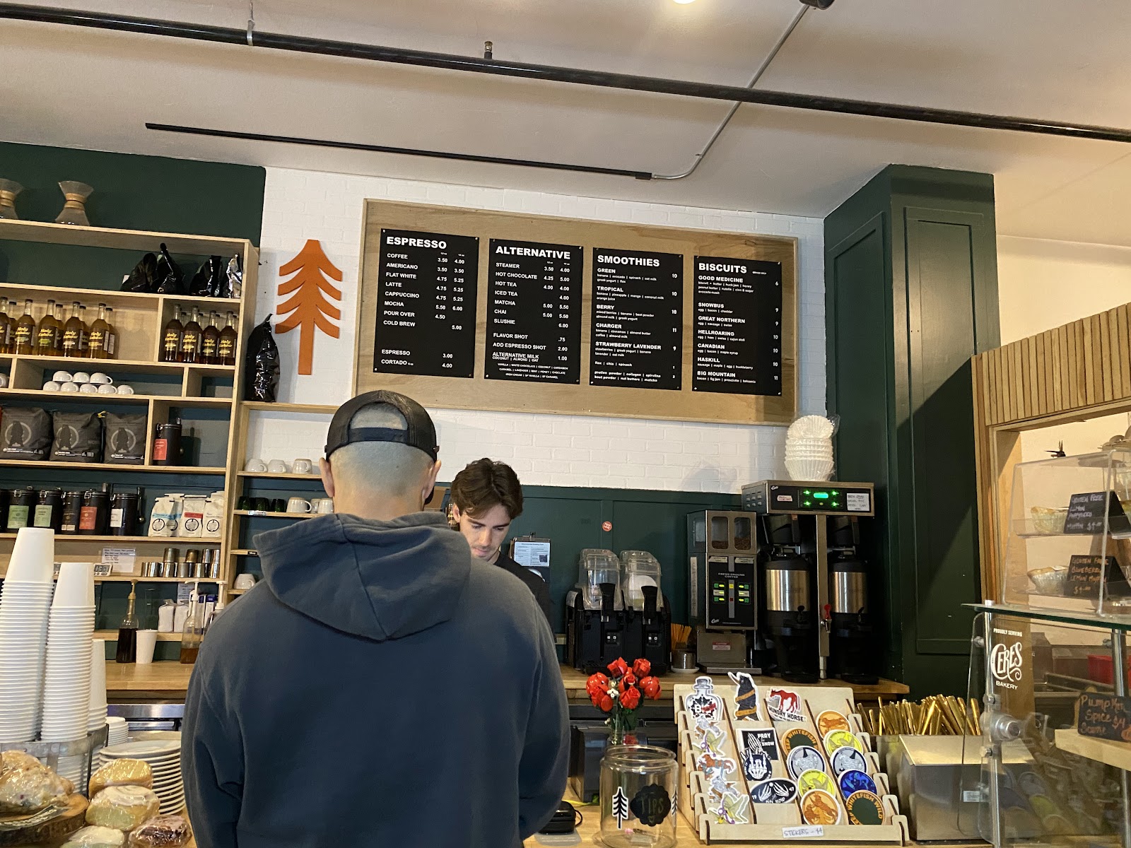 Interior of a Glacier National Park cafe with an espresso menu board and merchandise on display.