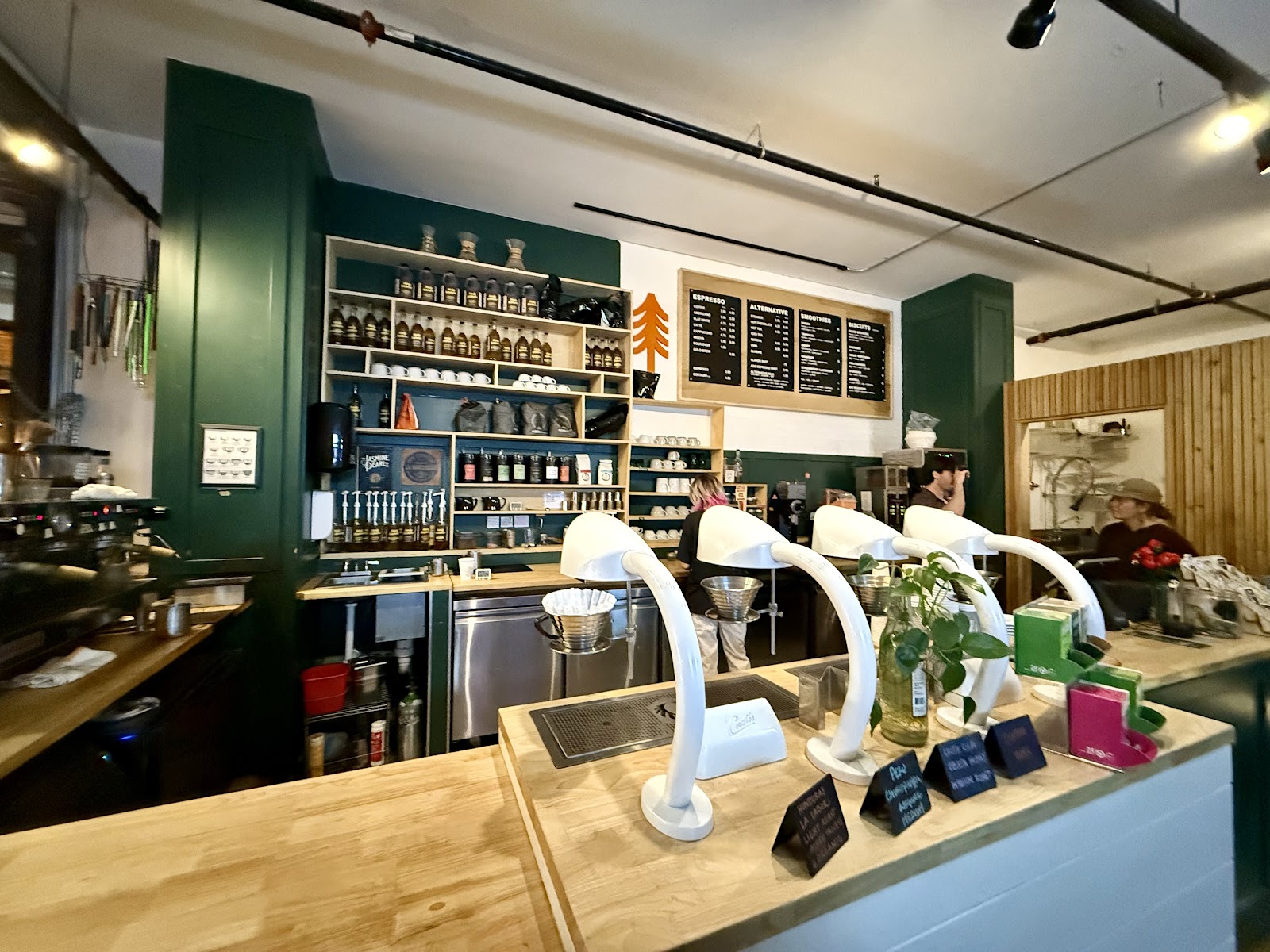 Cafe interior in Glacier National Park with a bar, shelves, and white coffee machines.