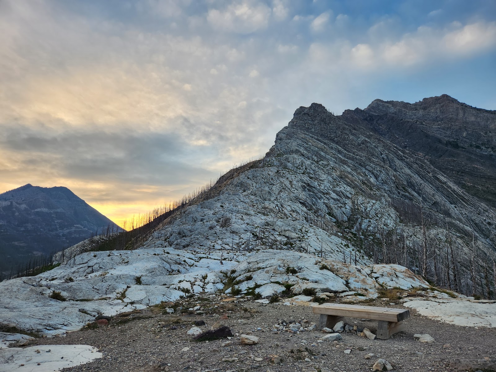 Bear's Hump Trailhead at Glacier National Park features rugged limestone ridges with a sunset glow over the rocky overlook.