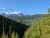 The Loop Trailhead in Glacier National Park offers a sweeping alpine valley with snow-capped peaks under a clear blue sky.