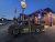 Twilight in Yellowstone National Park: rusted vintage pickup sits in front of a lit brick restaurant with flag and neon signs.