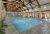 Indoor pool at a Yellowstone National Park lodging facility near West Yellowstone, featuring wooden beams and bright water.