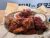 Glacier National Park takeout wings coated in glossy barbecue sauce from a park restaurant.