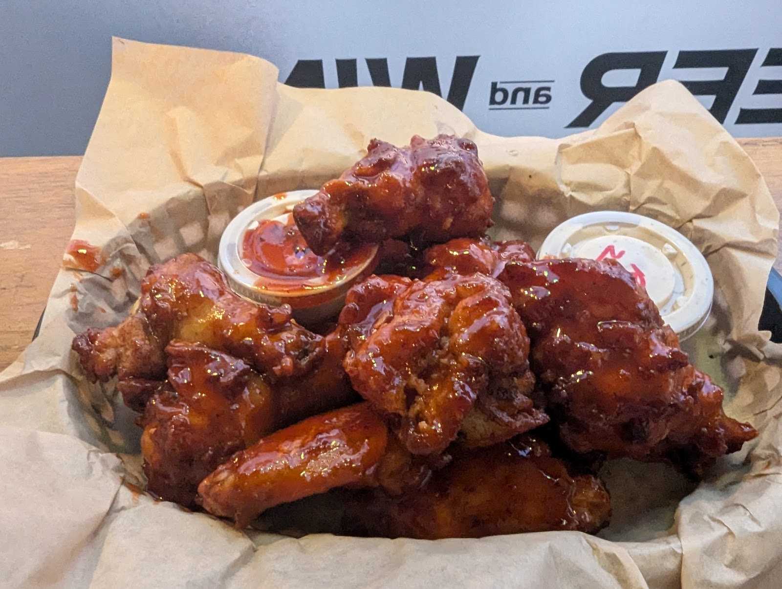 Glacier National Park takeout wings coated in glossy barbecue sauce from a park restaurant.