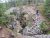 Natural Bridge overlook along a rocky trail in Yellowstone National Park, with stone steps and forested cliffs.