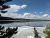 Lewis Lake in Yellowstone National Park reflects a clear sky with pine silhouettes and partial shoreline ice.