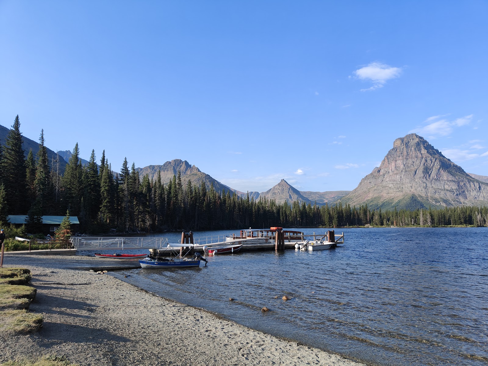 Two Medicine Picnic Area at Glacier National Park with a lake, pines, and distant peaks.