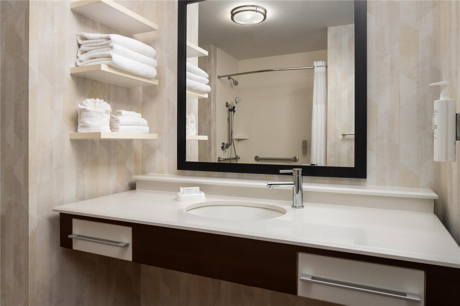 Hotel bathroom vanity with a large mirror and towel shelves in Glacier National Park area lodging near Whitefish.