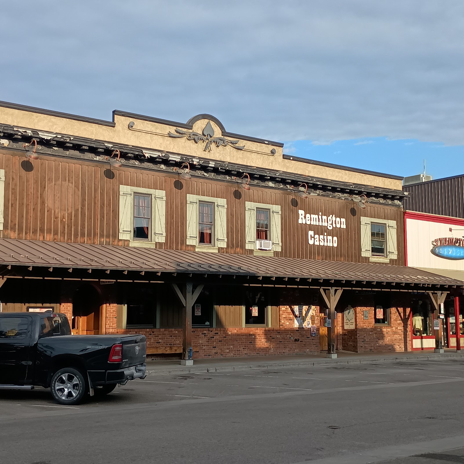 Remington Bar exterior, a rustic wood storefront with green window shutters in Glacier National Park.