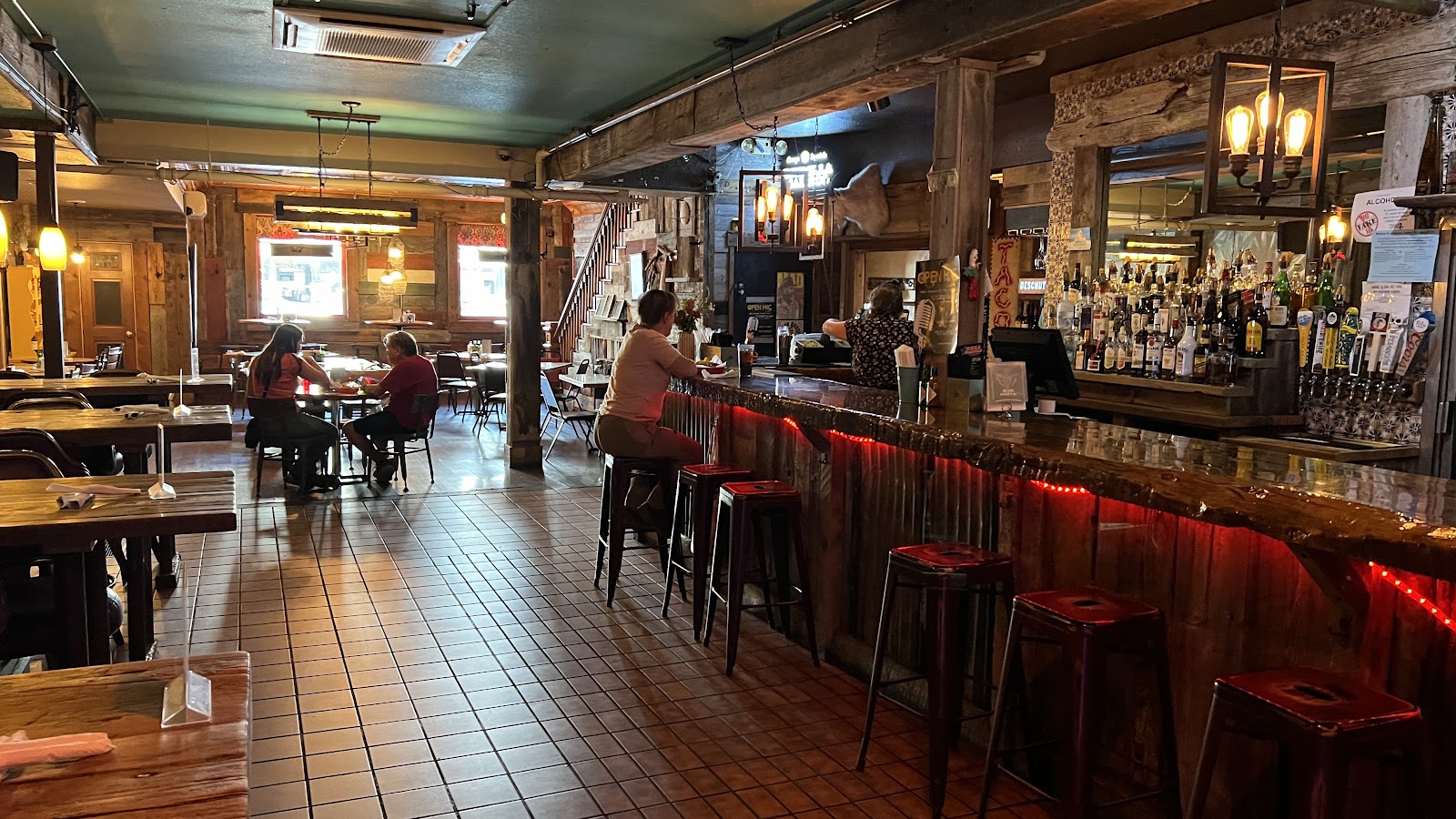 Interior at a rustic bar in Glacier National Park, with wooden beams and warm lighting.