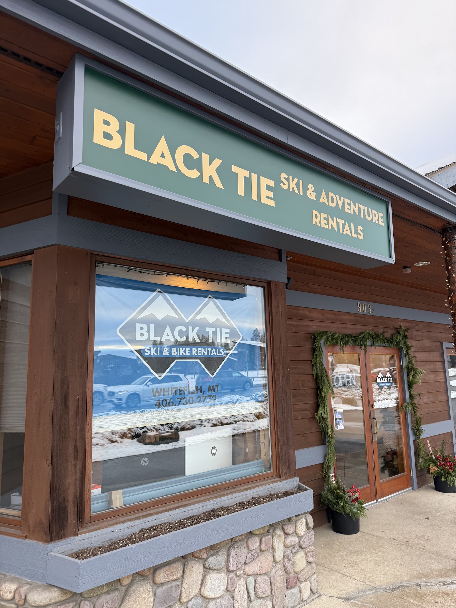 Ski and bike rental storefront in Whitefish, Montana near Glacier National Park, with a green sign and wooden trim.