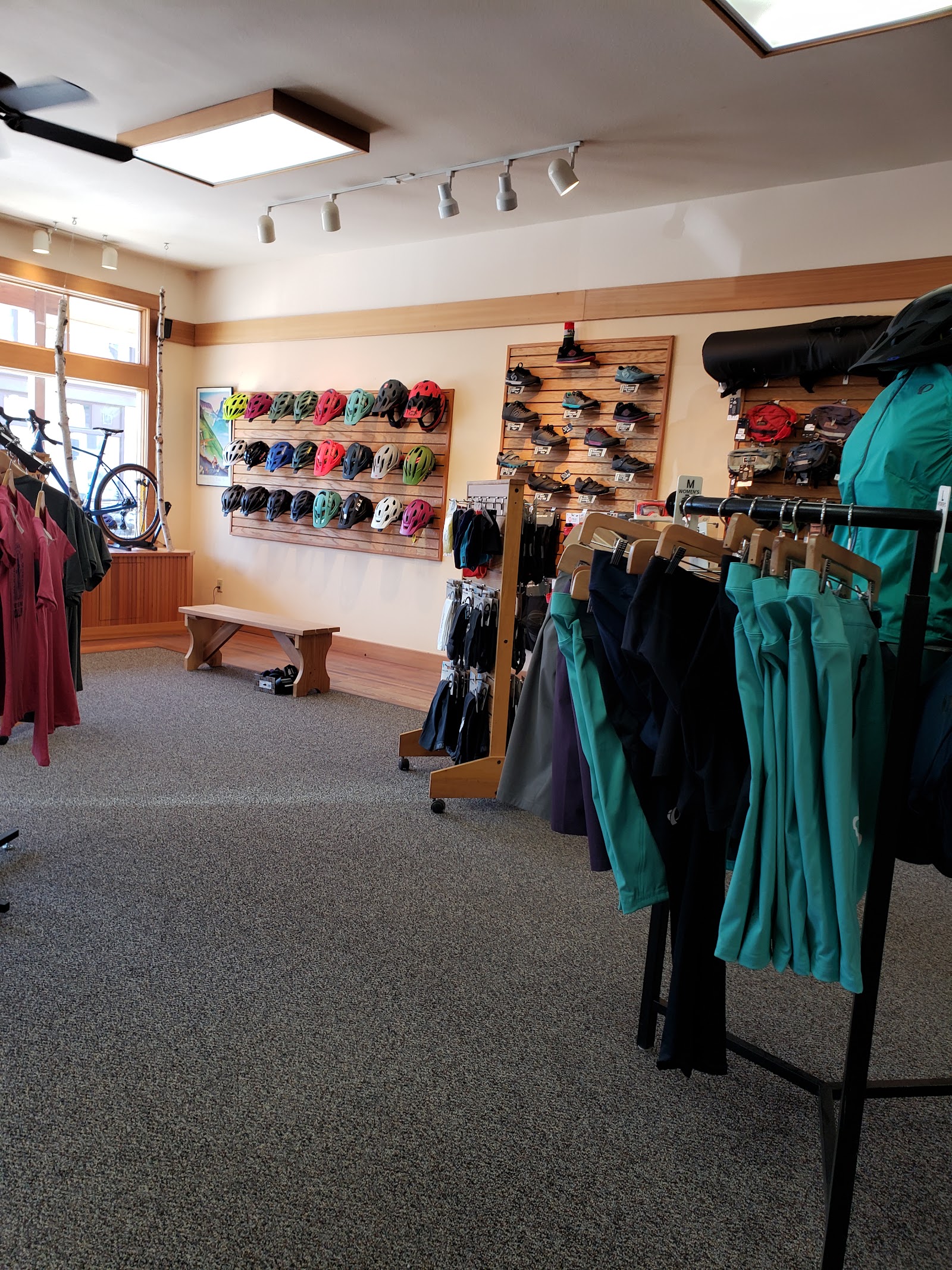 Inside Glacier National Park gift shop displaying cycling helmets, jackets, and outdoor gear.