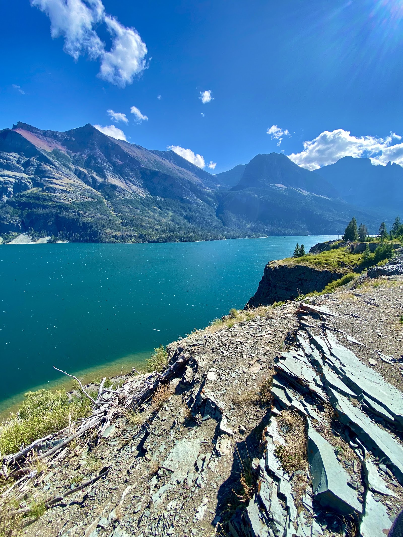 Saint Mary Lake with jagged Glacier peaks under a bright summer sky in Glacier National Park.