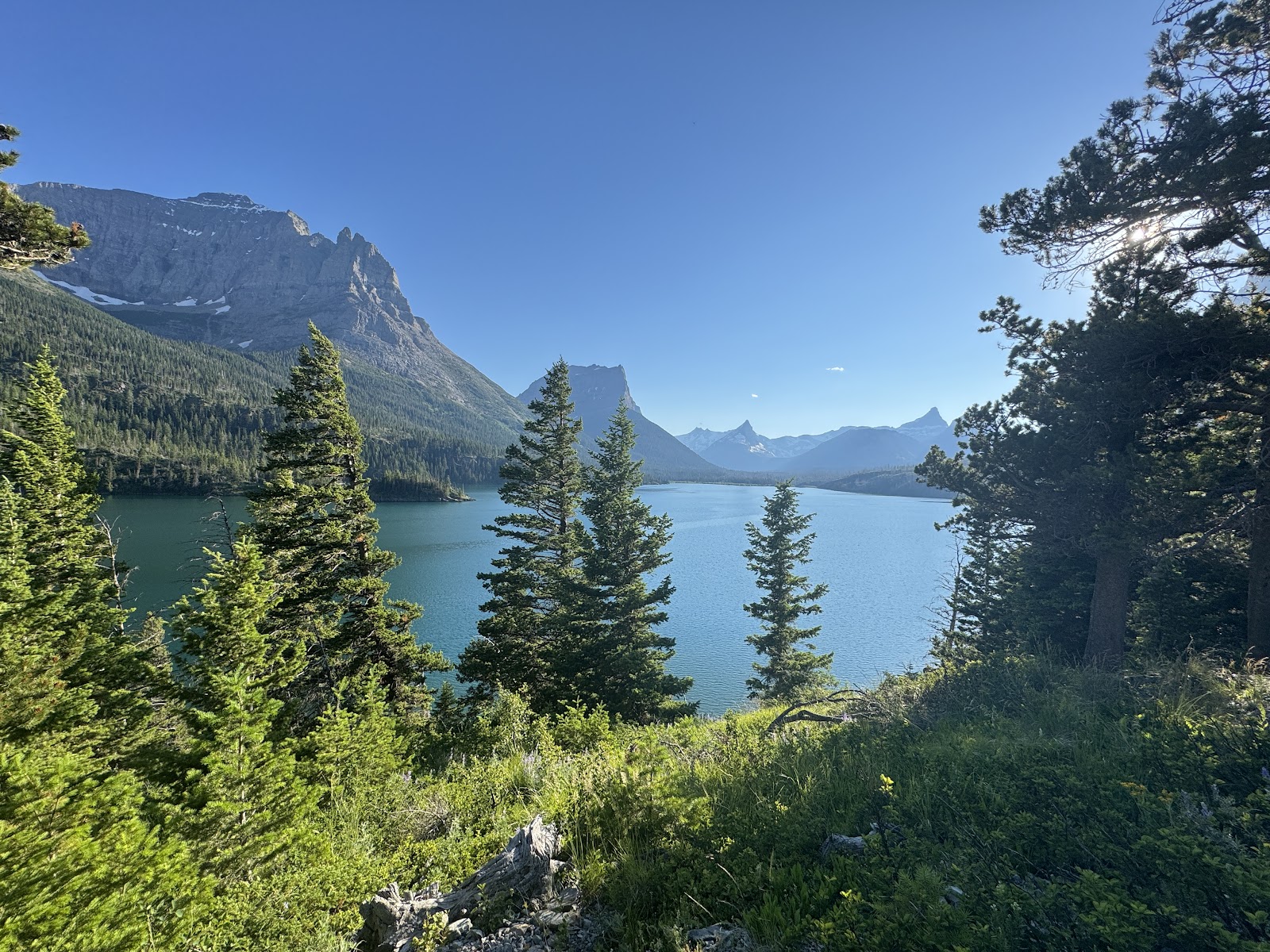 Rising Sun Picnic Area overlooks a turquoise lake framed by towering peaks in Glacier National Park.