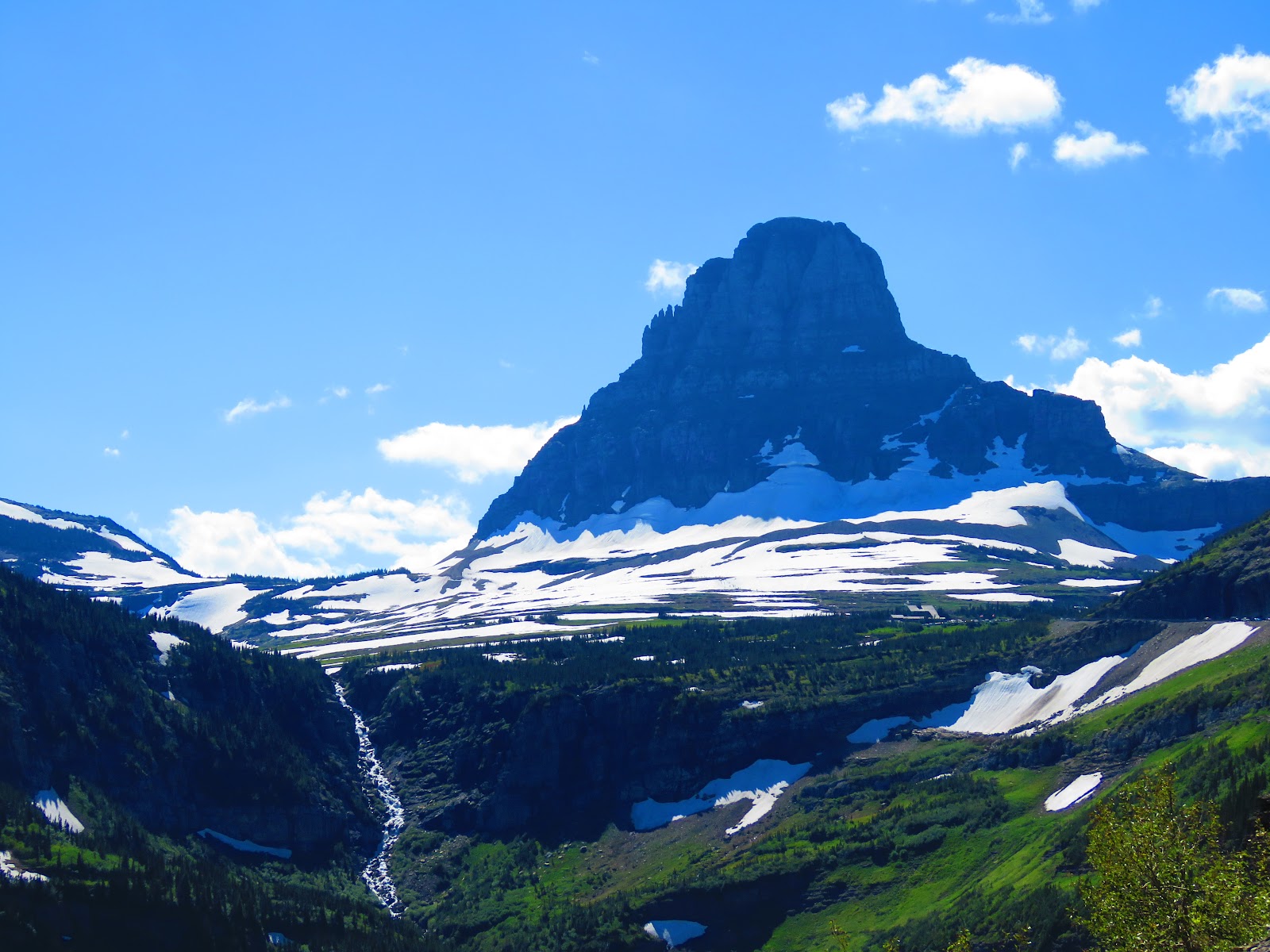 Going-To-The-Sun Mountain towers over snowfields in Glacier National Park, Montana.