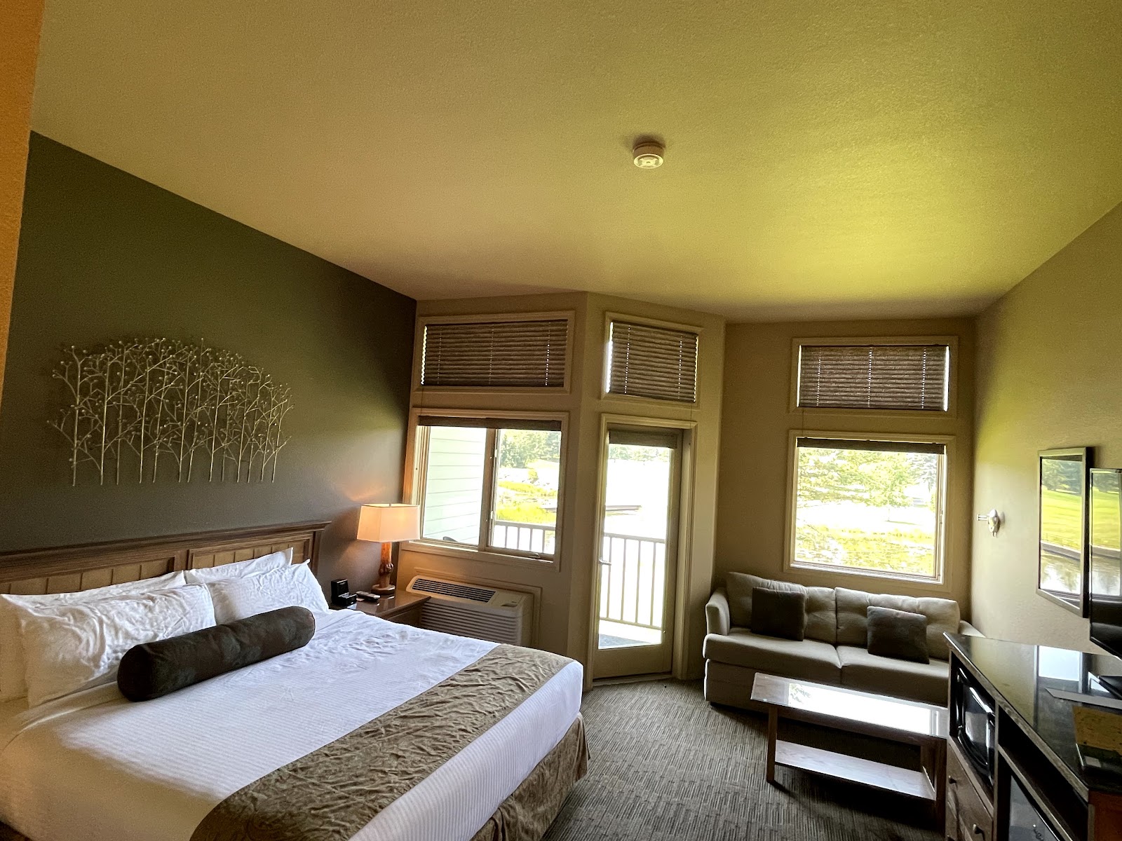 Contemporary lodge room inside Glacier National Park featuring a king bed, neutral decor, and a cozy seating area.