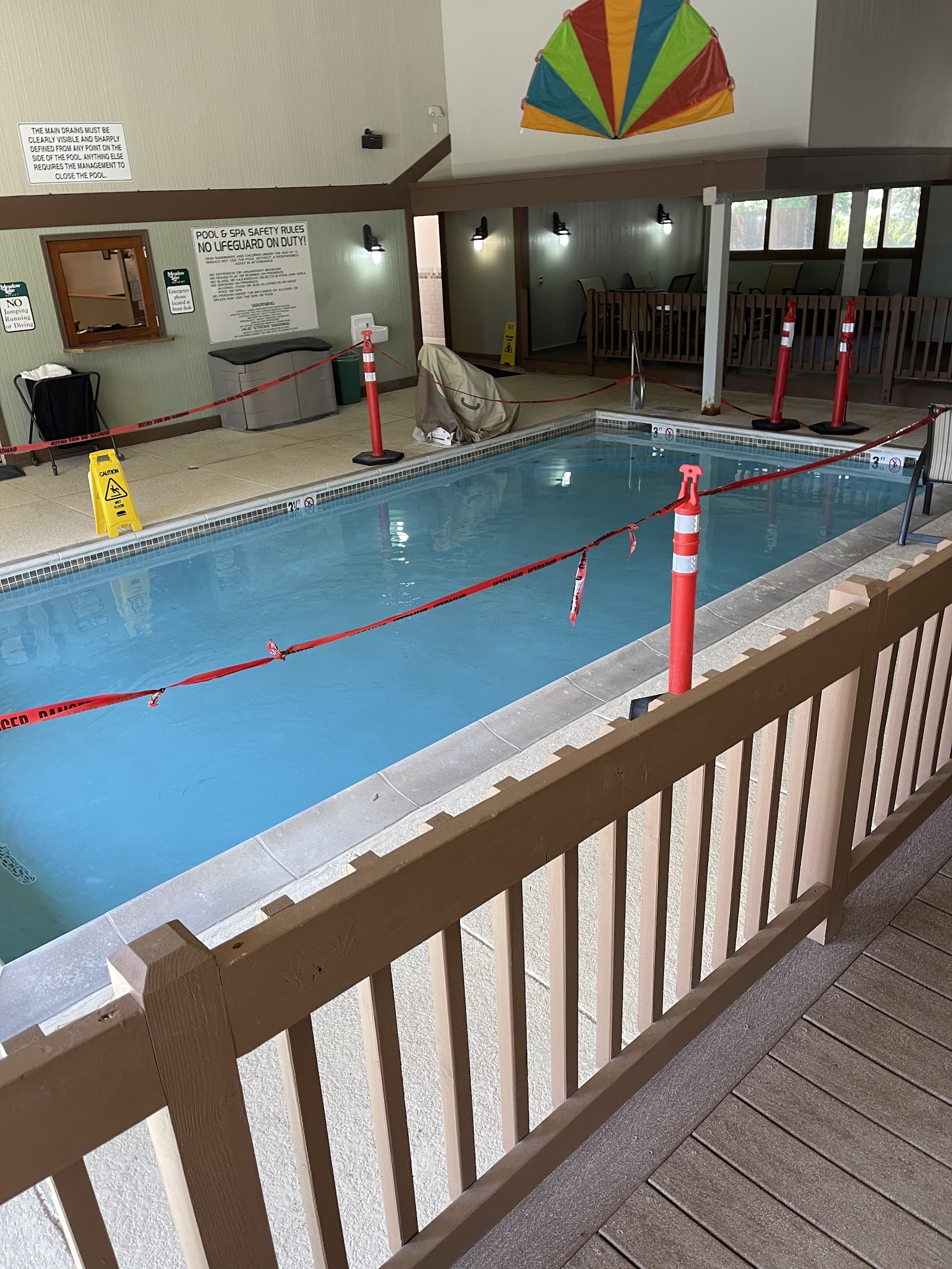 Indoor pool area at a Glacier National Park lodging facility, with red caution tape across the pool deck.