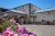 Exterior of the Yellowstone West Gate Hotel with blooming pink flowers in the foreground, Yellowstone National Park