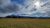 Columbia Falls meadow sprawls toward distant mountains under a dramatic sky in Glacier National Park.