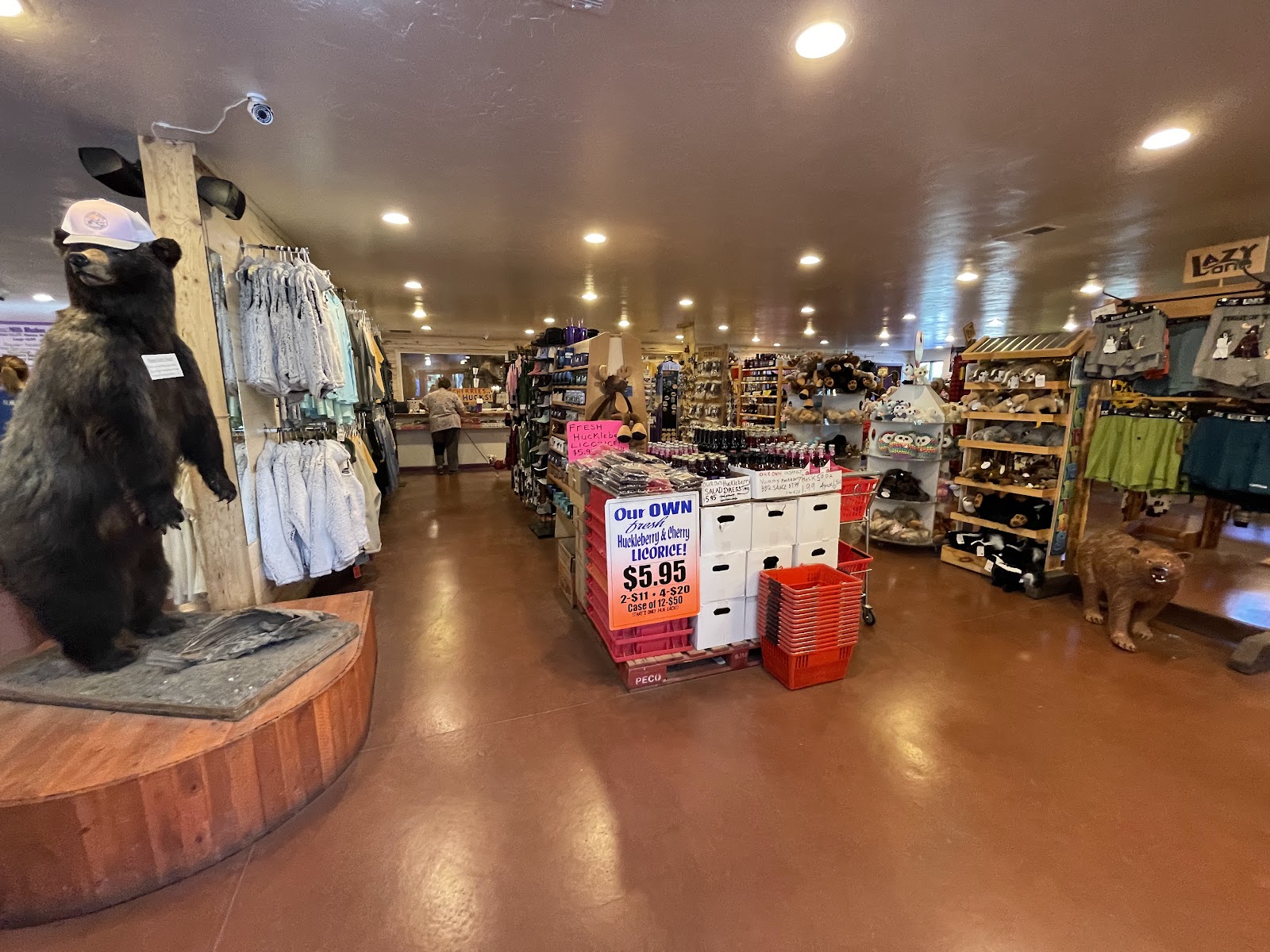 Inside Willow's Huckleberry Land gift shop at Glacier National Park, shelves stocked with souvenirs, clothing, and bear-themed items.