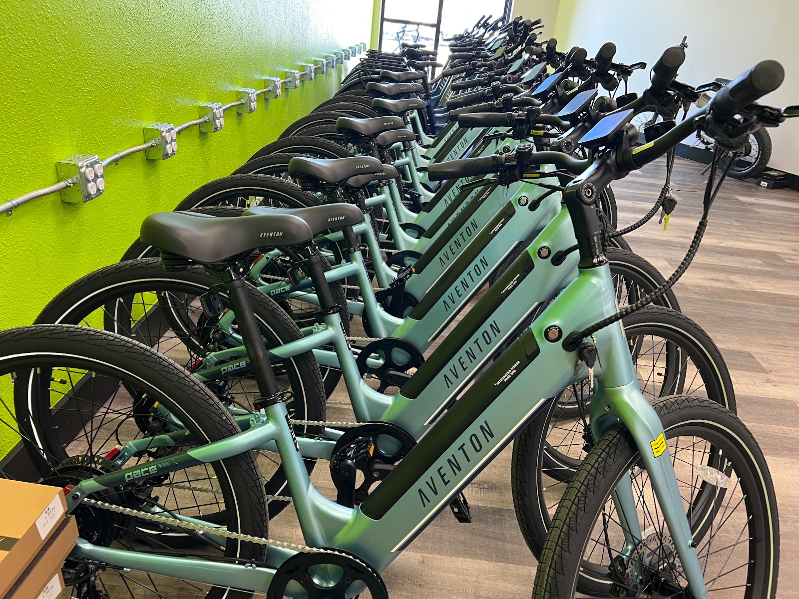 Row of teal Aventon e-bikes lined up inside a Glacier National Park gift shop.