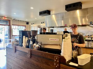 Inside a Glacier National Park cafe counter with espresso machines and baristas.
