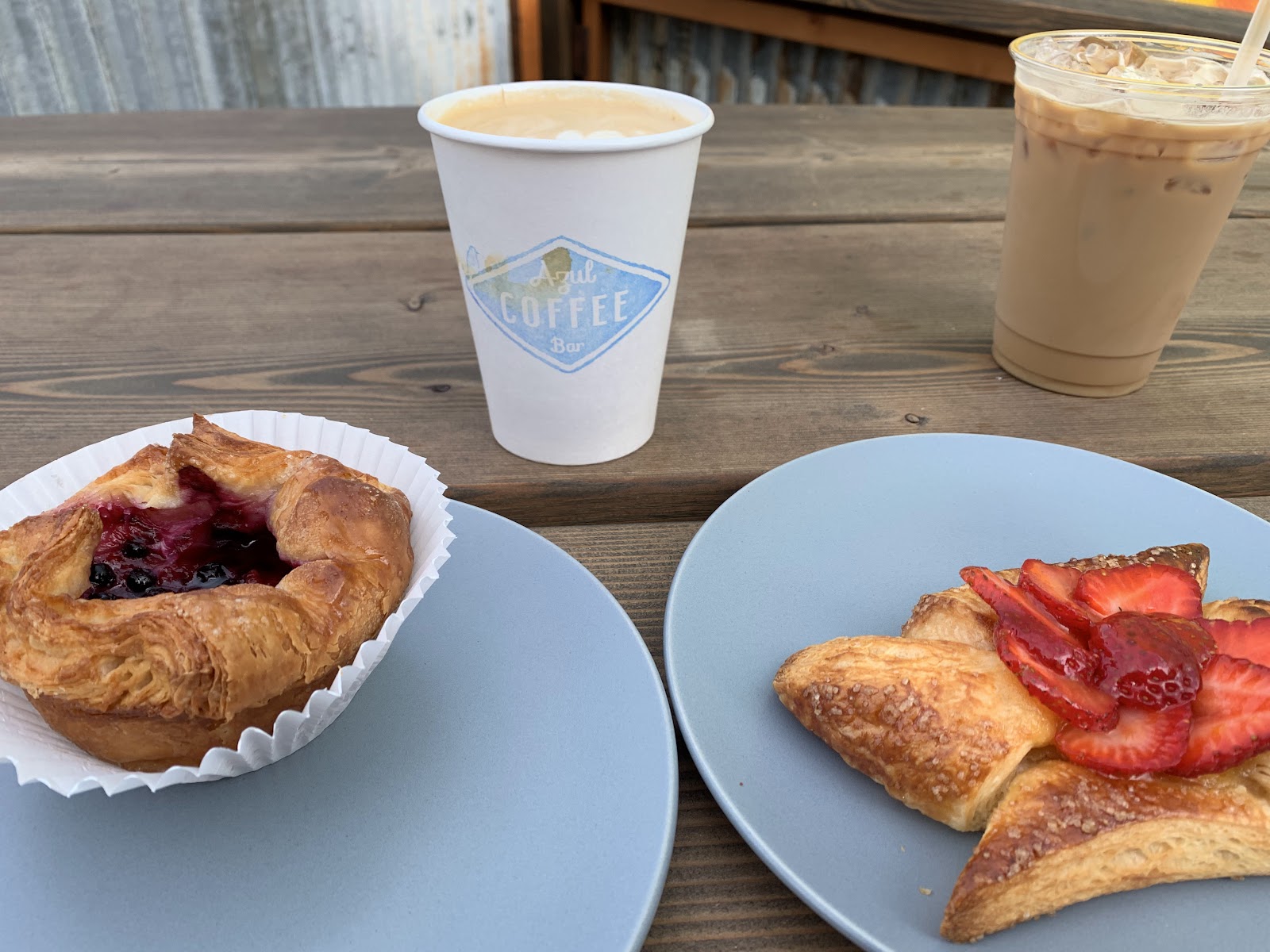 Berry pastry and iced coffee on a wooden table at a Glacier National Park cafe.