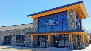 Gift shop storefront at Glacier National Park with a stone exterior, large glass windows, and wooden beam accents.