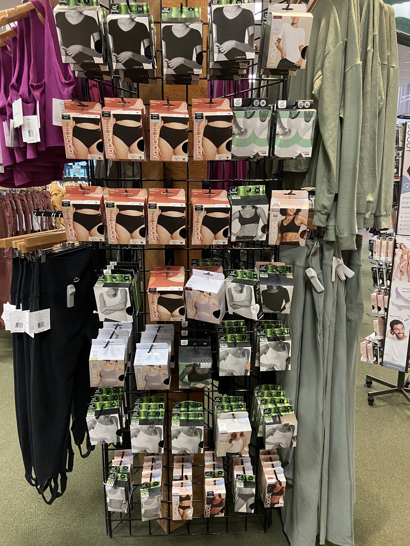 Interior gift shop display at Glacier National Park featuring assorted packaged underwear and athletic wear on a grid rack.