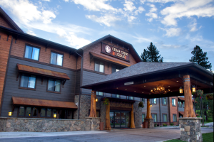 Exterior view of a rustic lodge at Glacier National Park near Cedar Creek, showcasing stone and wood architecture.