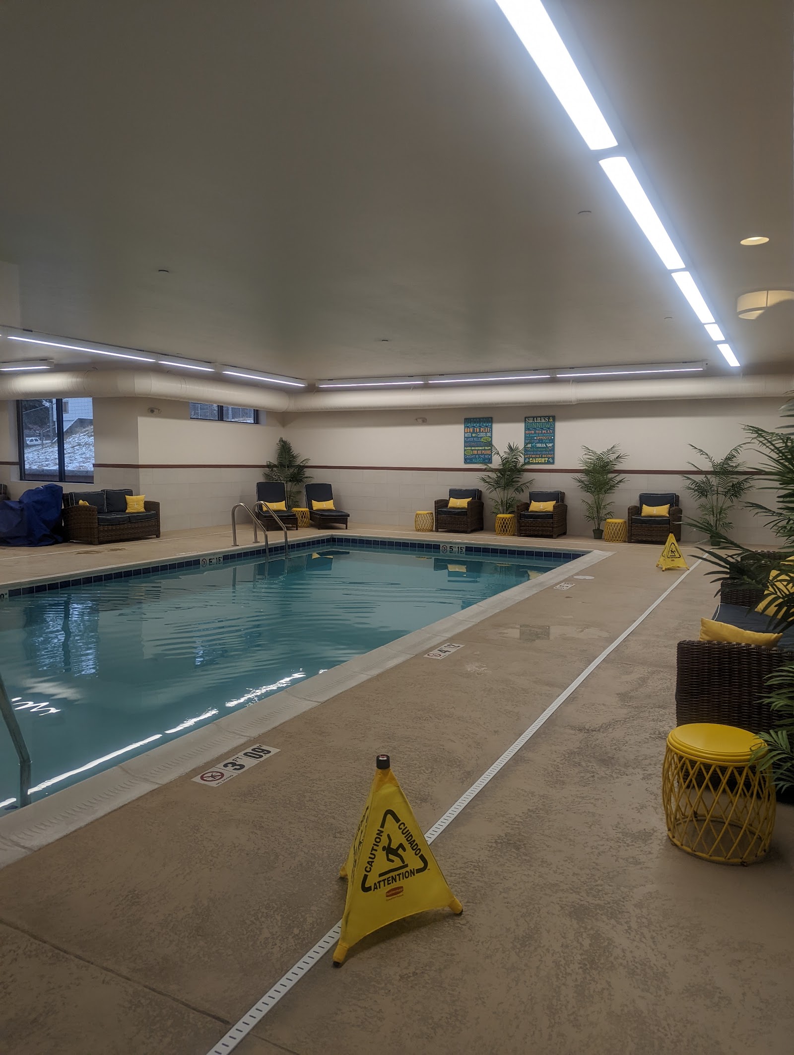 Indoor pool area at a Glacier National Park lodge, with poolside seating and tropical decor.