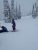 Winter scene of two skiers on a snow-covered Lakeside trail in Glacier National Park.