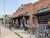 Exterior view of Yellowstone Grill along a brick storefront with outdoor patio seating in Yellowstone National Park.