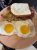 Plate of breakfast with two sunny-side eggs, hash browns, bacon and toast at Yellowstone National Park.