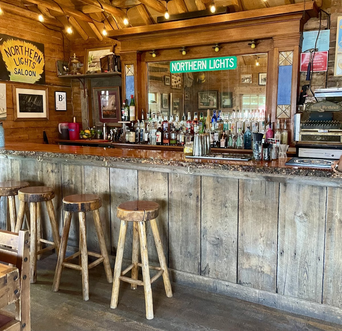 Rustic bar interior at a Glacier National Park saloon with wood paneling and warm string lights.