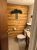 Knotty pine bathroom with a white toilet, tile floor, towel rack, and pine garland above a sign in Yellowstone National Park.