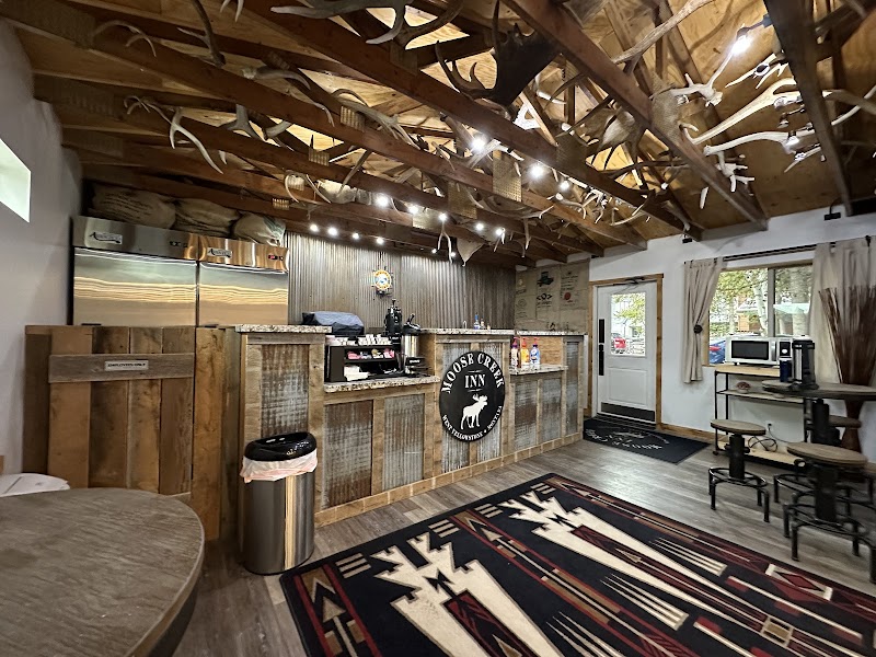 Rustic lodge lobby in Yellowstone National Park with a wooden reception bar, antler ceiling decor, and a Southwestern rug.