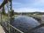 Fairy Falls Trailhead bridge over a winding river in Yellowstone National Park with steam plumes and grassy banks.