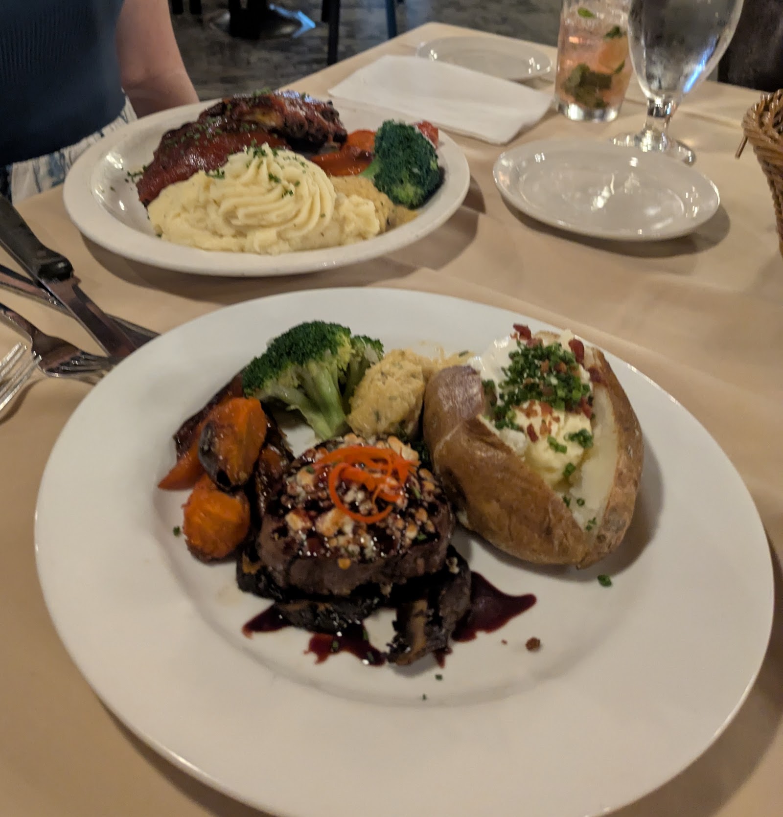 Glacier National Park dining plate with a grilled steak, mashed potatoes, broccoli, and vegetables in a casual restaurant setting.