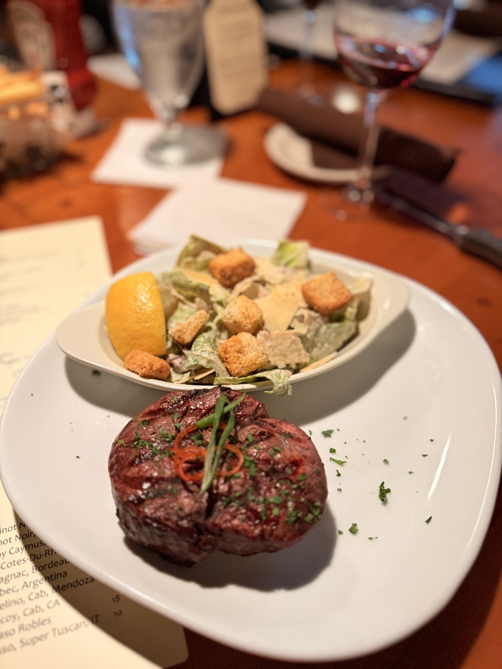 Steak dinner with a mixed salad and lemon wedge at a Glacier National Park dining venue near Whitefish Lake.