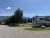 RV campground at Glacier National Park near Columbia Falls with trees, gravel pads, and distant mountains.