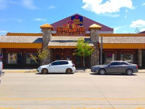 Rustic pub exterior with wooden facade, lantern lighting, and a chalkboard sign