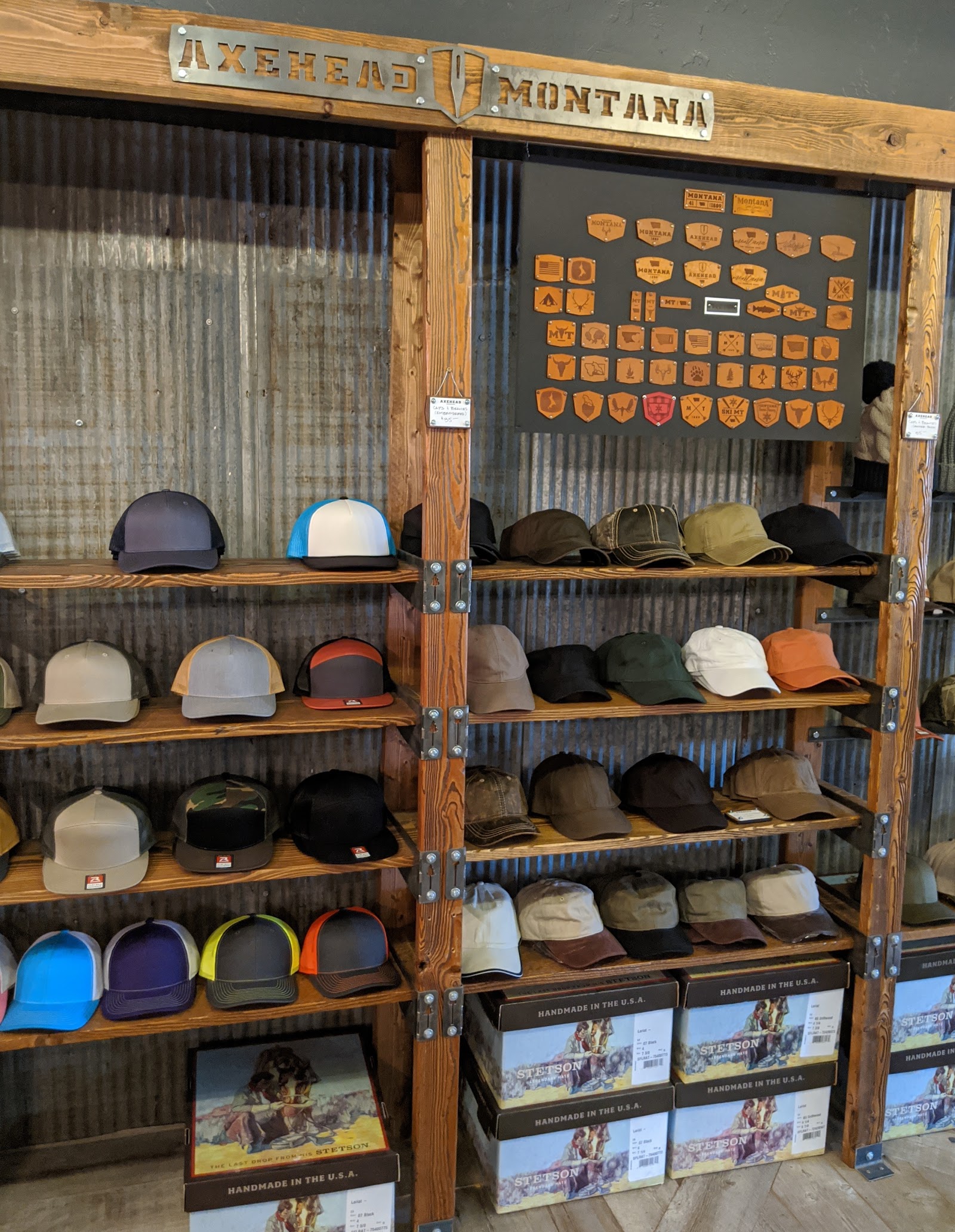 Hat display inside a Glacier National Park gift shop, with wood shelving and rows of outdoorsy caps.