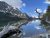 St. Mary Lake at Glacier National Park reflects jagged, snow-dusted peaks and a weathered driftwood shoreline.