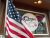Flag waves in front of a Glacier National Park shop window near Polebridge, Montana, advertising coffee.